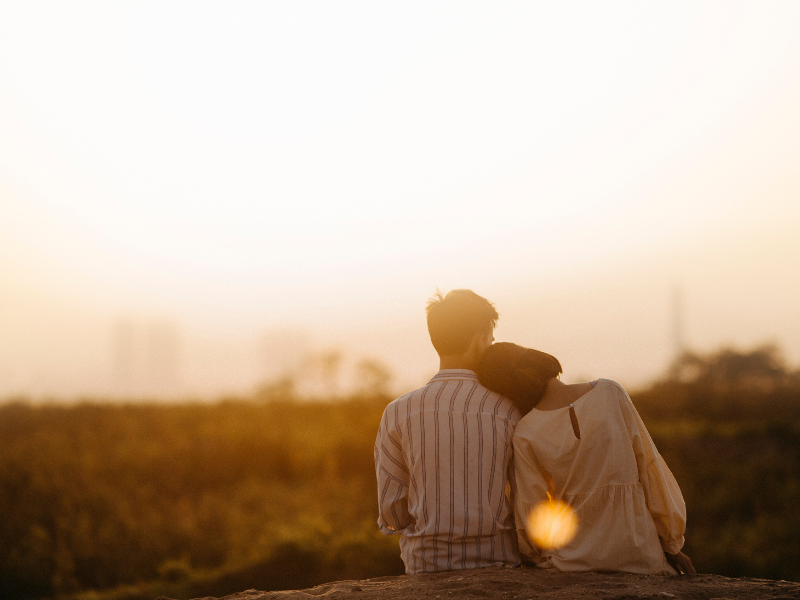 夕暮れの中で寄り添う夫婦の後ろ姿